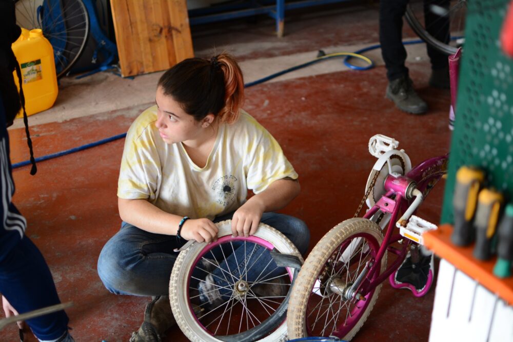 Dina Melamed fixing a bicycle at Pnimeet in Jaffa. Photo courtesy of Pnimeet