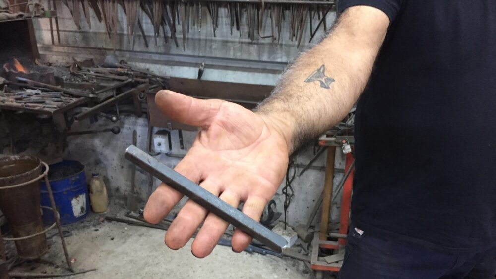 Walied Khoury shows the iron rod that he will soon fashion into art. Photo by Diana Bletter
