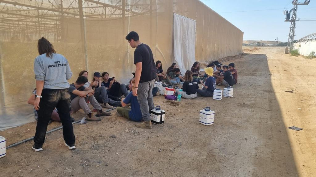 HaShomer HaChadash agricultural volunteers taking a break, on a moshav in southern Israel. Photo courtesy of HaShomer HaChadash