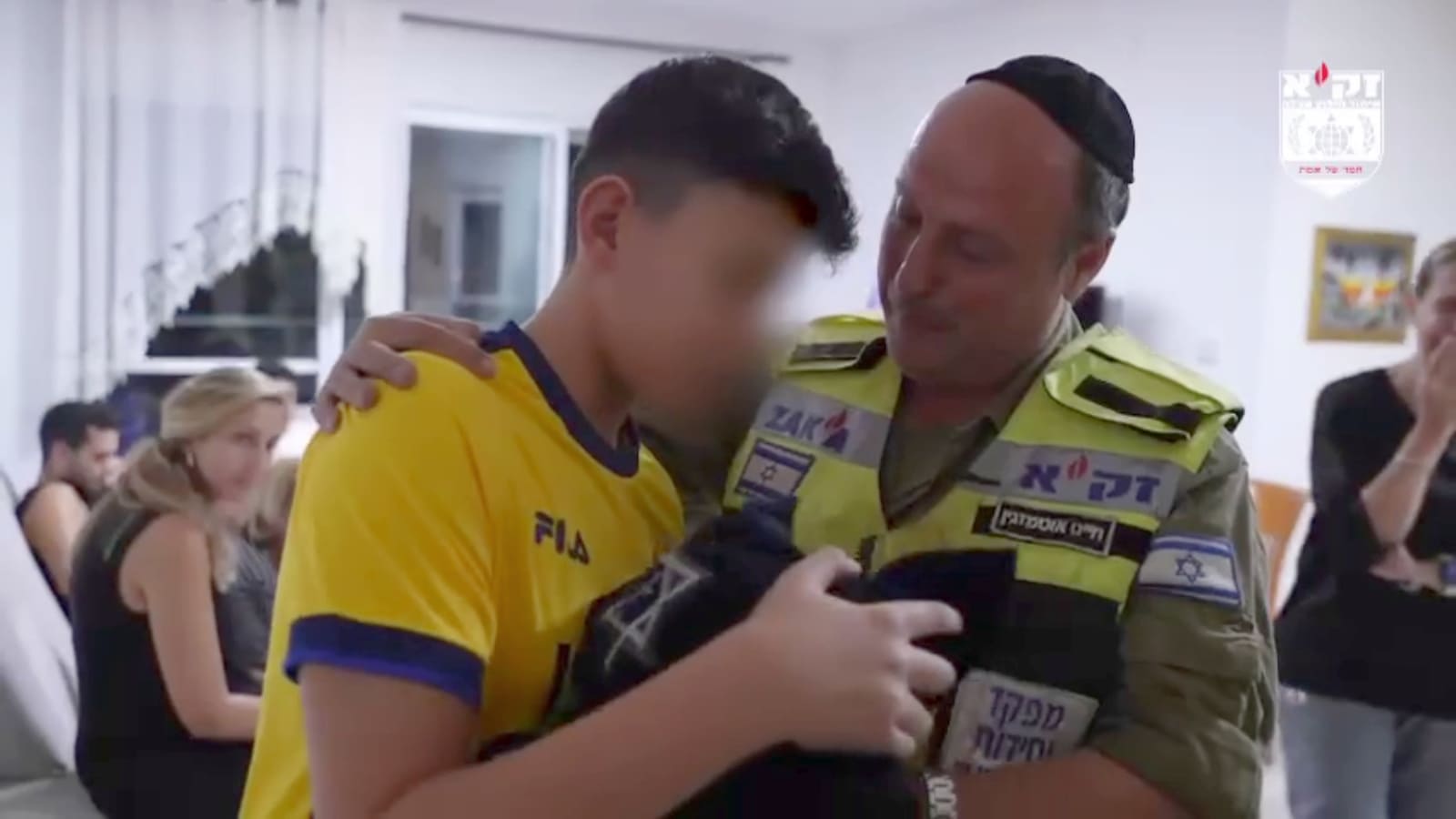 Ariel Zohar receiving his dead father’s tefillin from ZAKA volunteer Chaim Otmazgin. Photo: screenshot