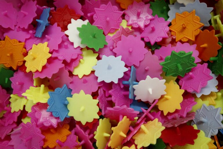 A pile of colorful plastic interlocking dreidels in pink, green, yellow, purple, orange, and white.