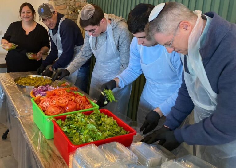 Basma Hino, left, with volunteers packing food for soldiers and displaced families. Photo courtesy of Noor