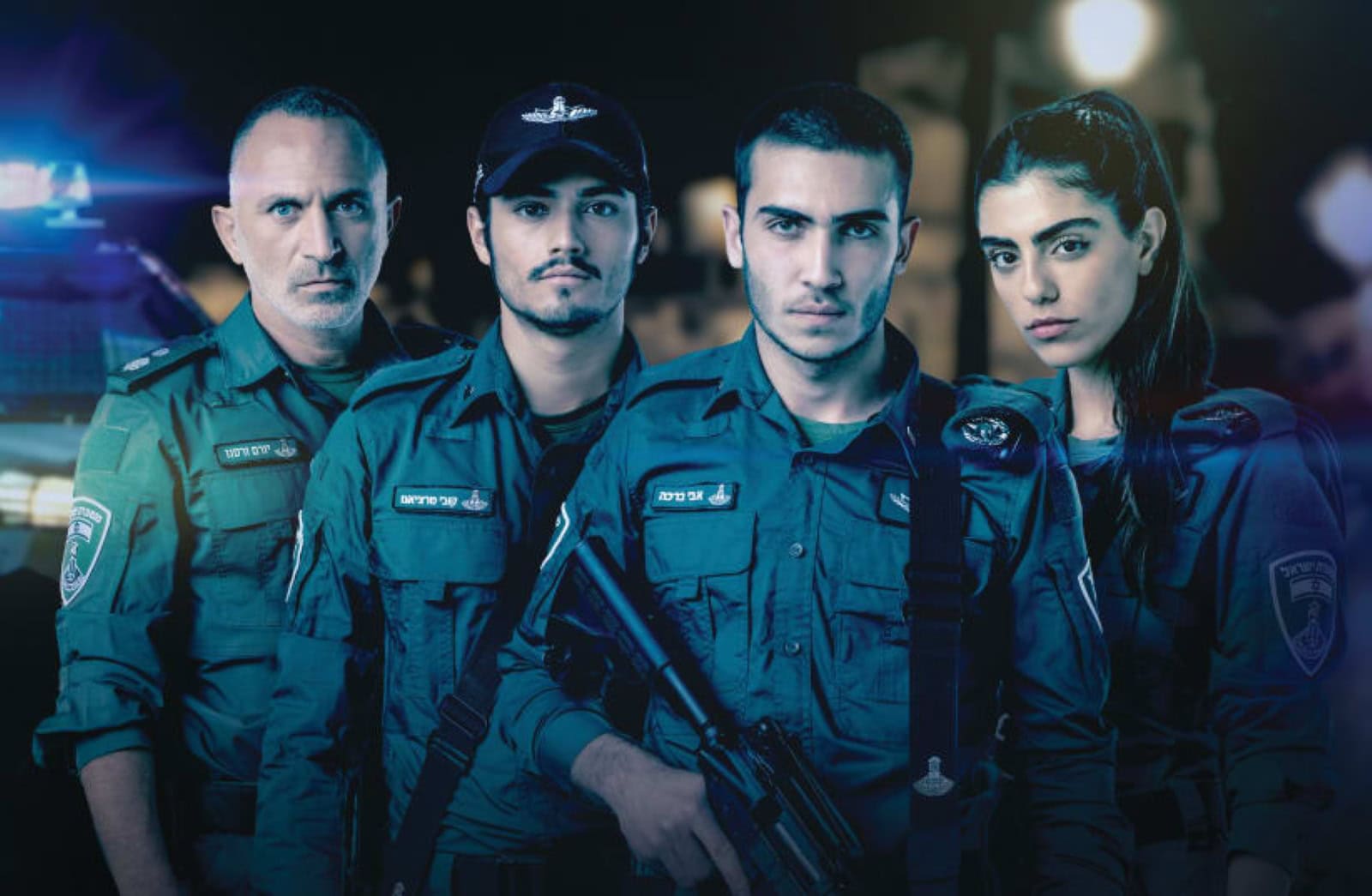 The cast of 'Borders,' in uniform stand together, three men and a woman. They appear serious and focused, with one holding a rifle. A police vehicle with flashing lights is visible in the background.