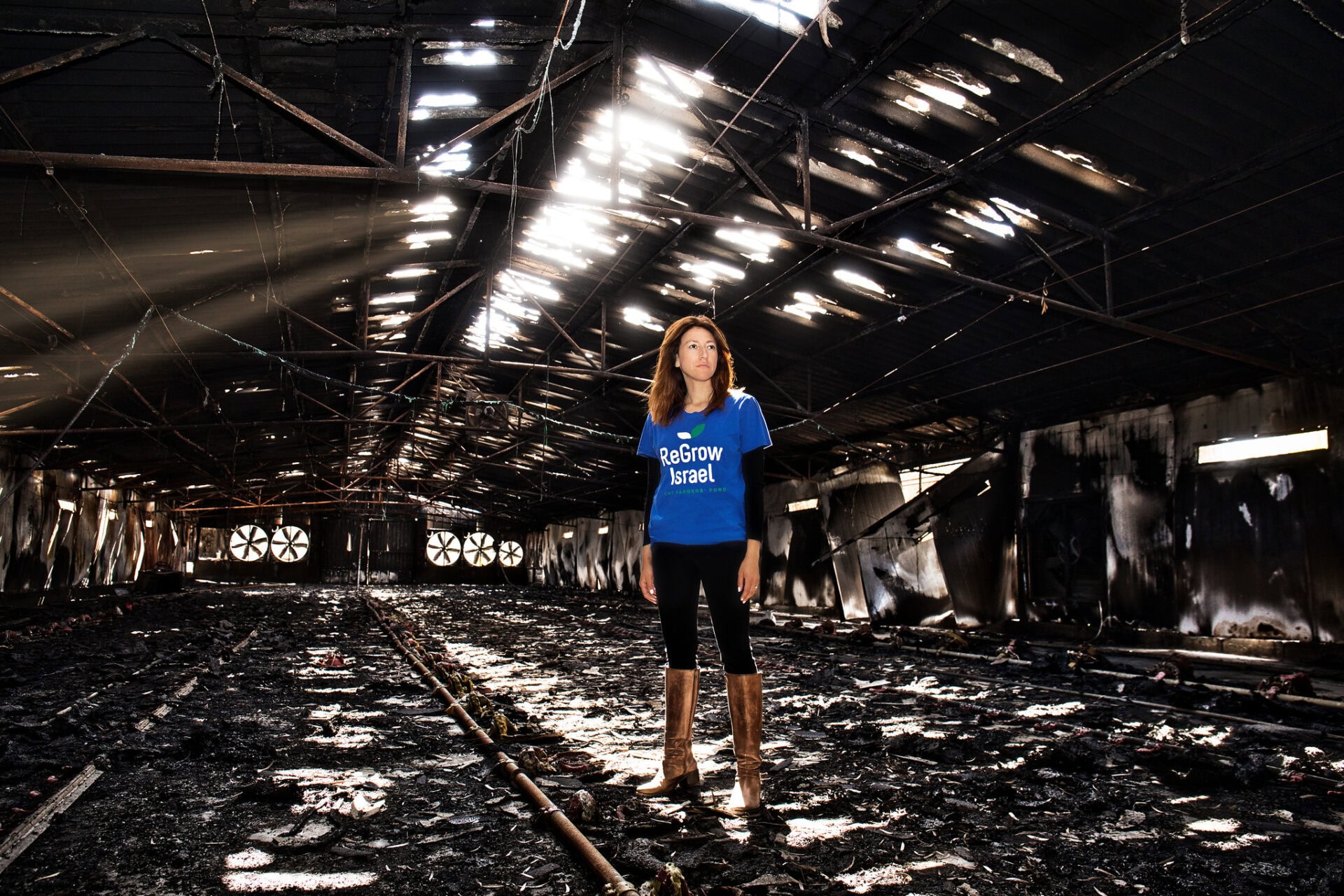 Danielle Abraham stands in an agricultural shed destroyed by Hamas terrorists on October 7, in Nir Oz. Photo by Noam Chen
