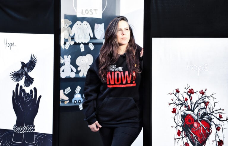 Dorit Gvili poses with art work in Hostages Square in Tel Aviv. Photo by Noam Chen