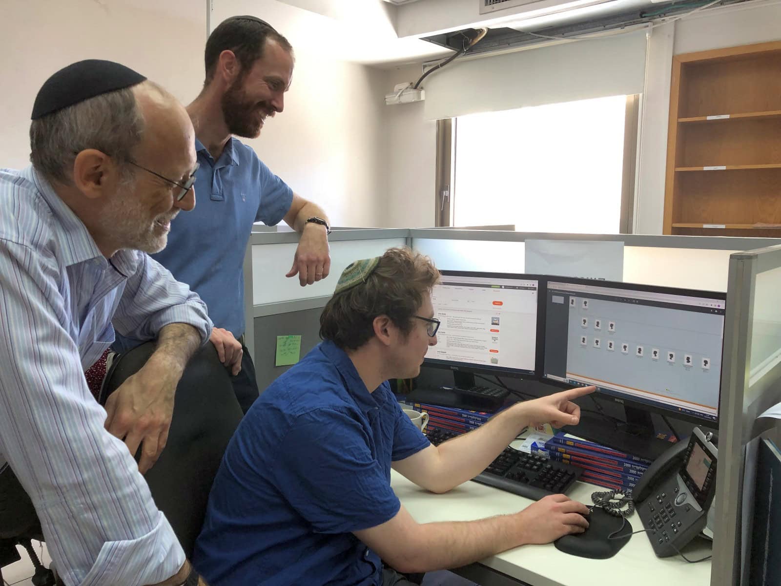 From left, Jonathan Kirsch, department head in the unit for the location and restitution of unclaimed property; JCT team leader Avraham Schumacher; and researcher Quincy Barrett discussing a JCT file.