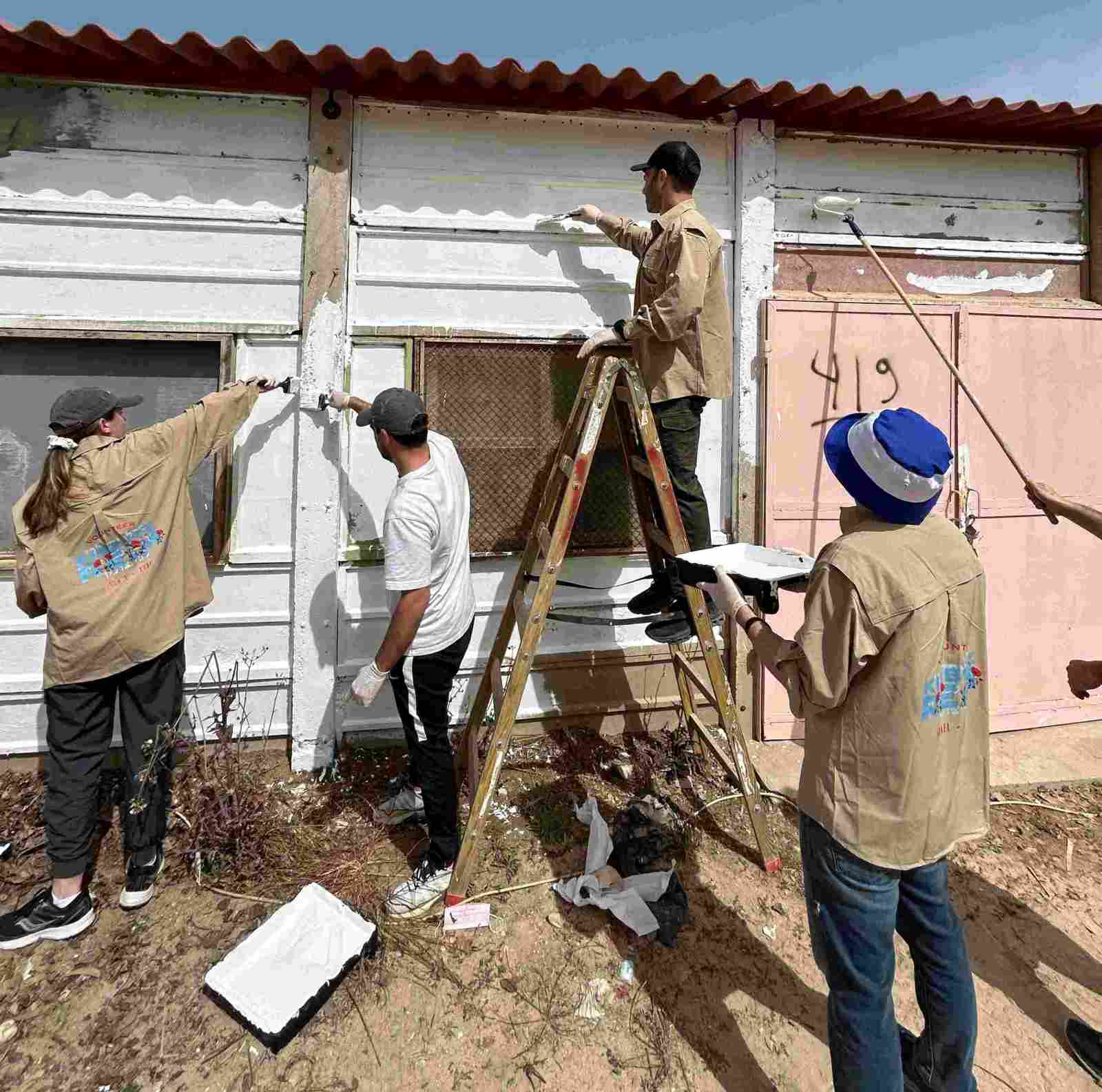 Members of the New York delegation paint a structure in Kibbutz Re’im. Photo by Aviv Lazar
