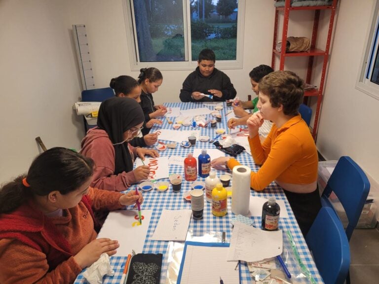 Afterschool homework at an FKI community club led by a volunteer. Photo by Ron Zeevi