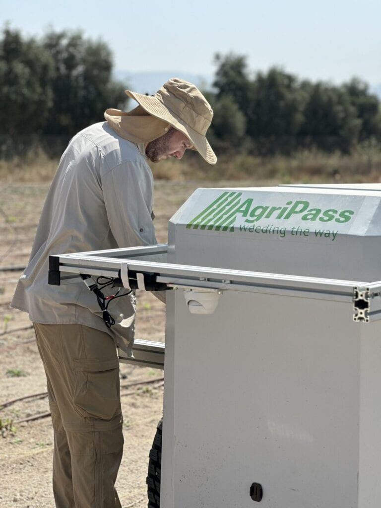 A professional inspecting the AgriPass weeding machine. Photo courtesy of AgriPass