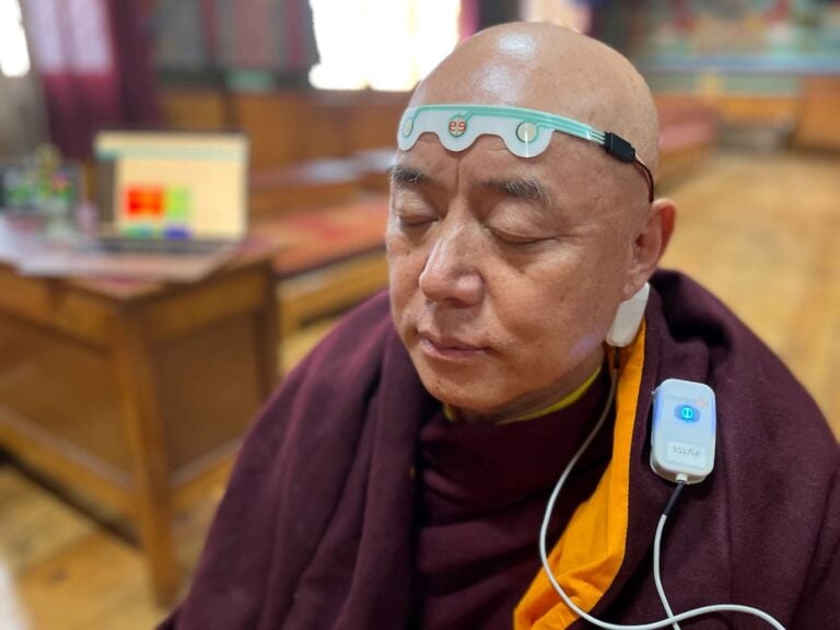 Neurosteer monitoring a Tibetan monk during meditation. Photo © 2023 Neurosteer Inc. All rights reserved.