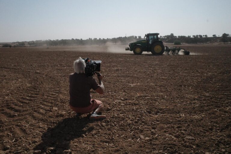 Director of Photography Petr Cikhart films a tractor in a field near the Gaza border. Photo by John Coles