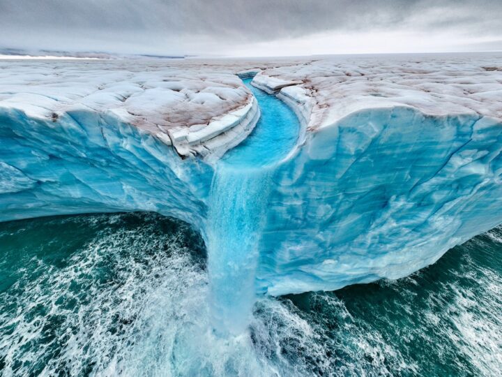 One of the TPOTY award-winning photos of waterfalls over Bråsvellbreen. As these waters flow into the ocean, they accelerate coastal threats worldwide. Photo by Roie Galitz/TPOTY